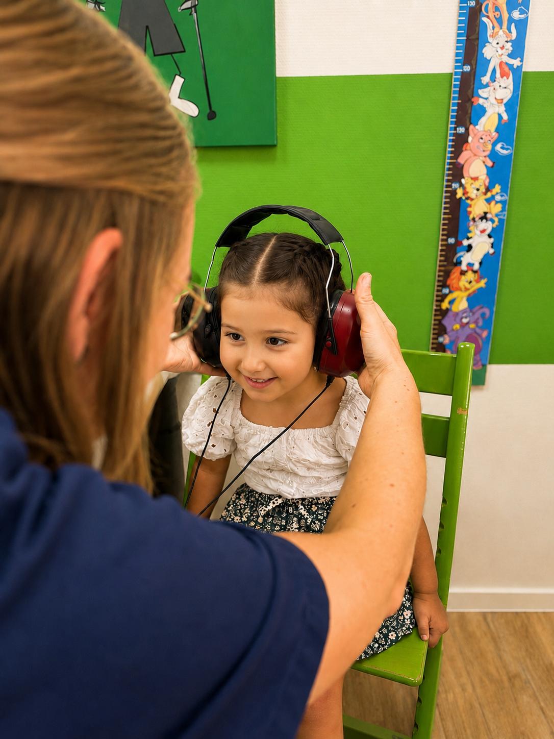 Hörtest bei einem Mädchen in der Kinderarztpraxis